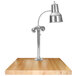 A Hanson Heat Lamps chrome carving station with a maple block base on a wooden table.