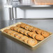 A MFG Tray Goldtex fiberglass bakery display tray of cookies on a counter.