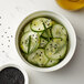 A bowl of cucumbers with black seeds.