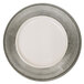 A white plate with a silver rim on a silver charger plate.