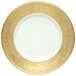 A white plate with a gold rim on a gold surface.