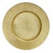 A Charge It by Jay gold glass charger plate with a circular sunburst design.