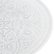 A white glass charger plate with silver designs on it.