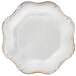 A white Charge It by Jay plastic charger plate with a decorative gold trim.