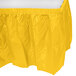 A yellow plastic table skirt with a white background.