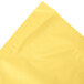A folded yellow Mimosa Yellow plastic table skirt on a white background.
