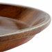 A round wooden tray with a white and brown rim.