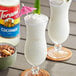 Two glasses of tropical drinks with Torani Coconut Flavoring Syrup and pineapple garnishes.