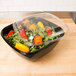 A salad in a Sabert black plastic catering bowl.