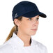 A woman wearing a Headsweats navy blue 5-panel cap with a terry sweatband.