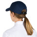 A woman wearing a navy blue Headsweats baseball cap with a ponytail.
