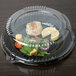 A plastic container with food and a WNA Comet 10" PET lid on it.