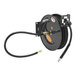 A black Equip by T&S hose reel with a black hose attached.