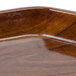 A Cambro Burma Teak fiberglass tray with a wood surface.