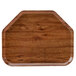 A trapezoid-shaped wooden tray with a brown finish on a table.