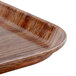 A close up of a Cambro Country Oak fiberglass tray with a brown stripe pattern.