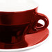 A close up of a red CAC Venice coffee cup and saucer.