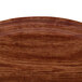 A close-up of a wooden surface with the Cambro Country Oak fiberglass tray design.