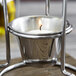 A Vollrath butter melter with a lit candle inside on a table.