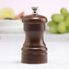 A Chef Specialties walnut pepper mill with a wooden cap.