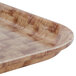 A Cambro dark basketweave fiberglass tray with a wooden pattern.