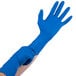 A person wearing blue High Risk Latex Exam Gloves.