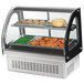 A Vollrath curved glass heated countertop display case with food inside.