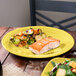 A plate of salmon and vegetables on a yellow Fiesta® dinner plate.