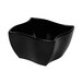 A black Elite Global Solutions square melamine bowl with a curved edge.