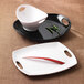 Two white melamine rectangular platters with handles displaying a white bowl and black plate with a red pepper.