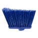 A blue Carlisle broom head with long, unflagged bristles.