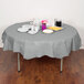 A table with a Creative Converting Shimmering Silver Table Cover with food and drinks on it.