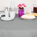 A table with plates, cups, and a Creative Converting Shimmering Silver OctyRound Table Cover.