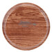 A round wooden Cambro tray with a logo on it.