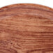 A close up of a Cambro Java Teak round fiberglass tray with a brown rim.