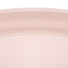 A close up of a light peach Cambro tray with an oval surface.