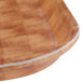 A close up of a Cambro square fiberglass tray with a basketweave pattern on a wood surface.
