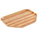 A trapezoid wooden tray with stripes on a counter.