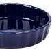 A blue fluted china quiche dish with a ruffled edge.