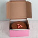 A chocolate cake in a pink 8" x 8" x 4" bakery box.