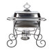 A silver metal Choice wrought iron chafer stand on a table.