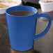 A close up of a Carlisle Ocean Blue Tritan mug with a handle.