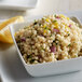 A white bowl of Del Destino Israeli Toasted Pearl Couscous with a lemon wedge.