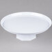 A Fineline white cake stand with a round base holding a white plate.