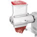 A Weston meat tenderizer attachment on a meat grinder with meat in it.