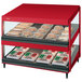 A red Hatco countertop display case with food on shelves.