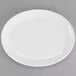 A Tuxton AlumaTux pearl white oval china platter with a white rim on a gray surface.