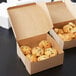 A Kraft cake box filled with cookies and croissants.