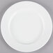 A Tuxton AlumaTux Pearl White china plate with a white rim on a gray surface.