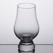 A Stolzle Glencairn whiskey glass on a table.